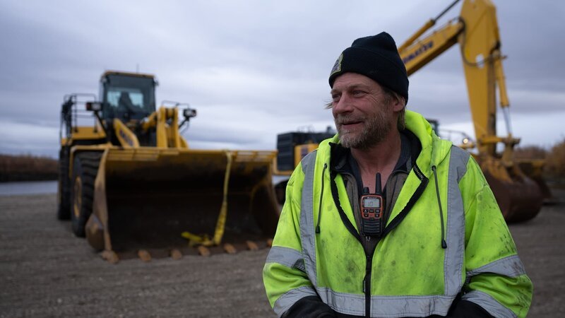 Shawn Pomrenke & bulldozer & excavator behind – Bild: Warner Bros. Discovery, Inc. or its subsidiaries and affiliates