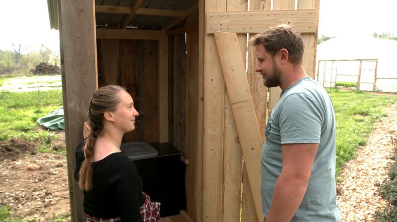 Marie Woeste und Lewis Zierke stehen vor der selbstgebauten Komposttoilette. – Bild: NDR/​WDR/​Melanie Grande
