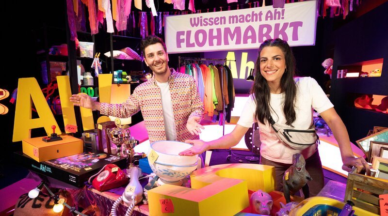 Kommt näher, liebe Zuschauerinnen und Zuschauer! Diesmal ist bei „Wissen macht Ah!“ alles käuflich: Clarissa und Tarkan veranstalten einen Flohmarkt. – Bild: WDR/​Thorsten Schneider