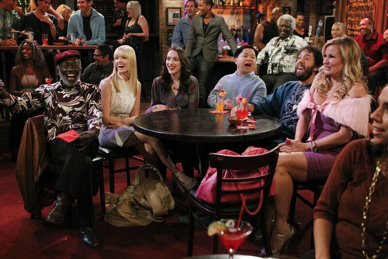 Darius bekommt von unerwarteter Seite Hilfe und schafft es tatsächlich, seinen Vater Earl, Caroline, Max, Han, Oleg, Sophie (v.l.n.r.: Garrett Morris, Beth Behrs, Kat Dennings, Matthew Moy, Jonathan Kite, Jennifer Coolidge) und den Rest des Clubs zum Lachen zu bringen … – Bild: Warner Brothers