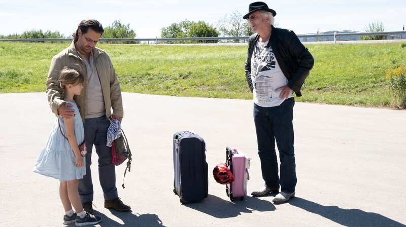 Autohof-Bekanntschaft: Nikos (Adam Bousdoukos, Mitte) und seine Tochter Marie (Panka Simon, li.) wollen bei Hartmut (Günther Maria Halmer, re.) mitfahren. – Bild: ARD Degeto/​Kerstin Stelter