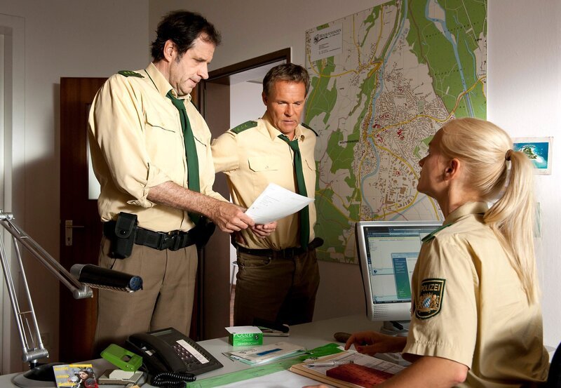 Polizeioberwachtmeisterin Sonja Wirth überreicht Hubert und Staller die Angaben zu einem neuen Einsatz. – Bild: ARD/​TMG/​Katrin Krammer