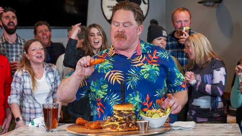 Host Casey Webb taking on the Menu Burger Challenge at Fox and Hound in Lake Tahoe as seen on Man v. Food, season 6. – Bild: Food Network /​ Discover Images: TCWF607_TCWF_Ta /​ Discovery, Inc.