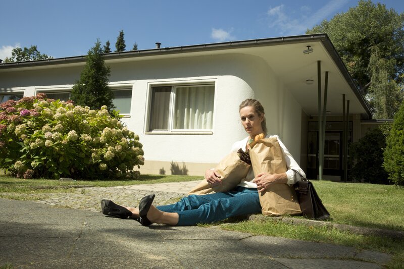 Carmen (Lisa Martinek) sitzt fassungslos auf dem Rasen und lauscht dem Gesang ihres Mannes und einer weiblichen Begleitung. – Bild: ZDF/​Volker Roloff