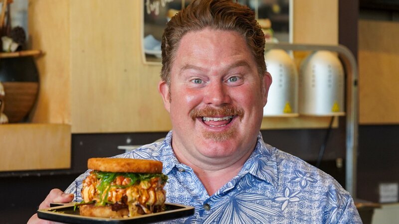 Host Casey Webb posed with the sushi burger at Jjanga Steak & Sushi in Las Vegas, NV as seen on Man v. Food, season 6. – Bild: Food Network /​ Discover Images: TCWF608_TCWF_Ve /​ Discovery, Inc.