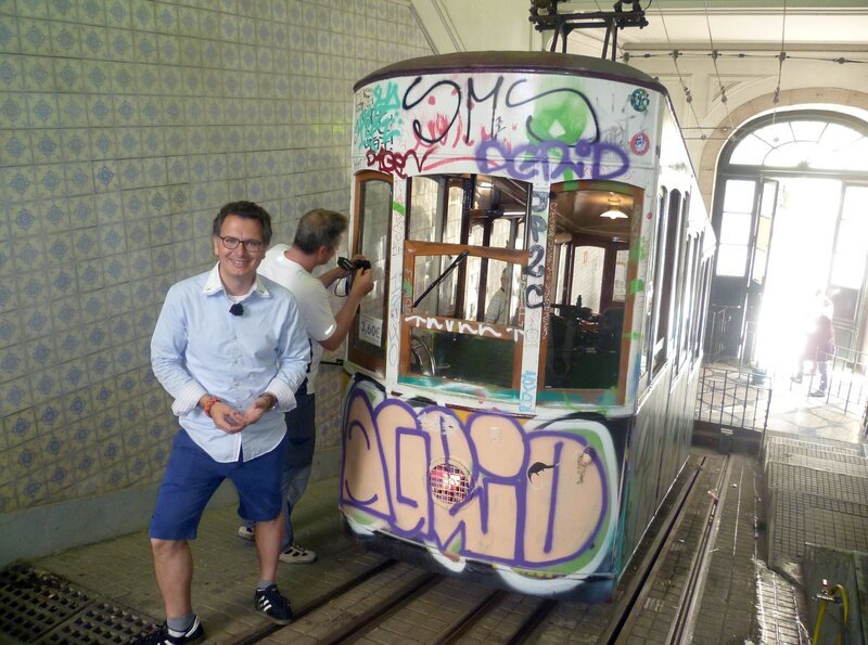 Moderator Michael Friemel vor der Lissabonner Standseilbahn Elevador de Bica. – Bild: SR/​Kerstin Woldt