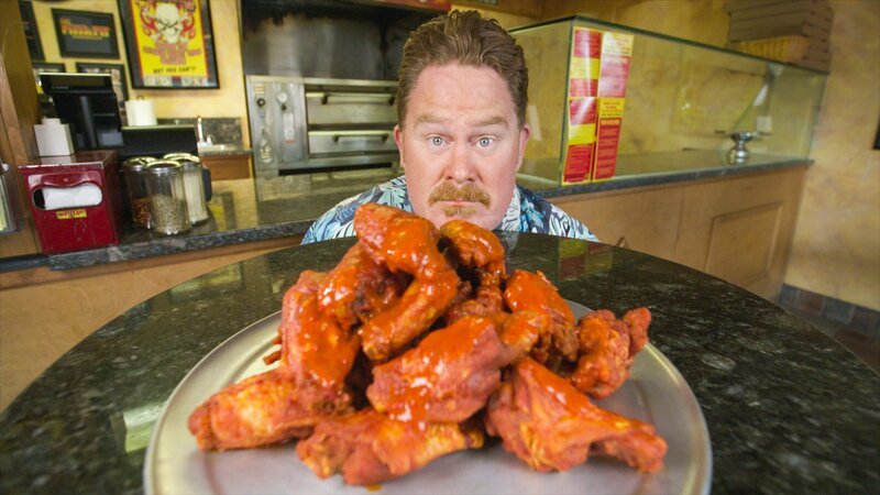Host Casey Webb posed with the Atomic Ghost Wing Challenge at the Pizza Pit in Hudson Valley, NY as seen on Man v. Food, season 6. – Bild: Food Network /​ Discovery Images /​ Discovery, Inc.