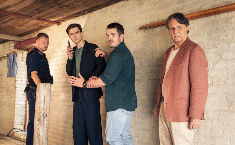 Ein Polizist, Julius Rosen (Sebastian Schneider, 2.v.l.), Gregor Weber (Felix Kreutzer, 2.v.r.) und Armin Weber (Wolfgang Bahro, r.) – Bild: RTL /​ Stephan Rabold /​ Im Kopf eines Killers