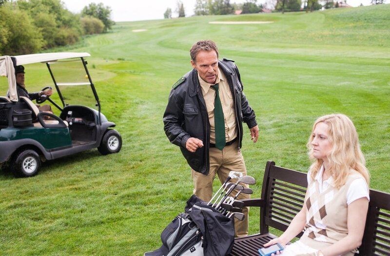 Hubert (Christian Tramitz, Mitte) und Staller (Helmfried von Lüttichau) finden die Bauunternehmerin Katja Sperlinger (Komparsin) auf dem Golfplatz – tödlich getroffen von einem Golfball. – Bild: ARD/​TMG/​Arvid Uhlig