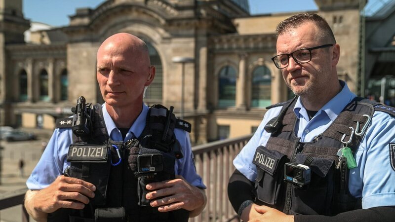 Two federal police officers (protagonists) are standing in front of the Dresden train station building. – Bild: DMAX Germany /​ Magis TV /​ Warner Bros. Discovery, Inc. or its subsidiaries and affiliates