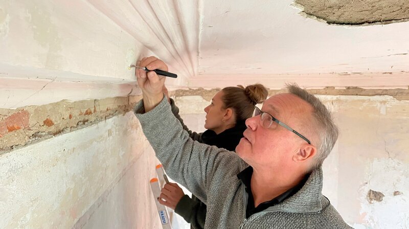 Abenteuer unter der Zimmerdecke: Gutshausbesitzerin Giulia Martinez legt gemeinsam mit Restaurator Harald Fahrnschon verborgene Ornamente an einer Stuckleiste frei: Sie sind mindestens 200 Jahre alt! – Bild: NDR/​populärfilm media GmbH