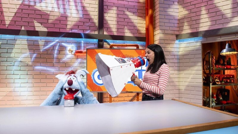 Woozle (re.) und Maria (li.) haben mit dem Lärm einer nahegelegenen Baustelle zu kämpfen. Als Woozle Krach mit Krach schlagen will, führt das zur Verwüstung des halben Studios. Die Studioleitung ist sauer und nutzt ausgerechnet eine von Woozles eigenen Erfindungen aus, um selbst mal ein bisschen Ruhe vor dem verrückten Erfinder zu haben. – Bild: Annette Etges/​SUPER RTL