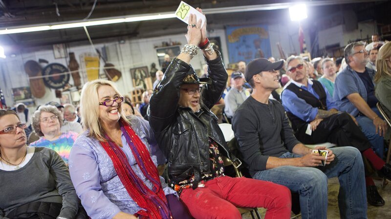 Laurence holds up his number and celebrates a winning bid in Nashville as Sally sits nearby and smiles. – Bild: The Travel Channel, L.L.C.