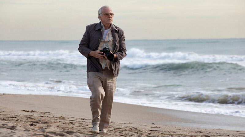 Victor Toura (Bernhard Schütz) entdeckt eine Leiche am Strand. – Bild: ARD Degeto/​Andrea Resmini
