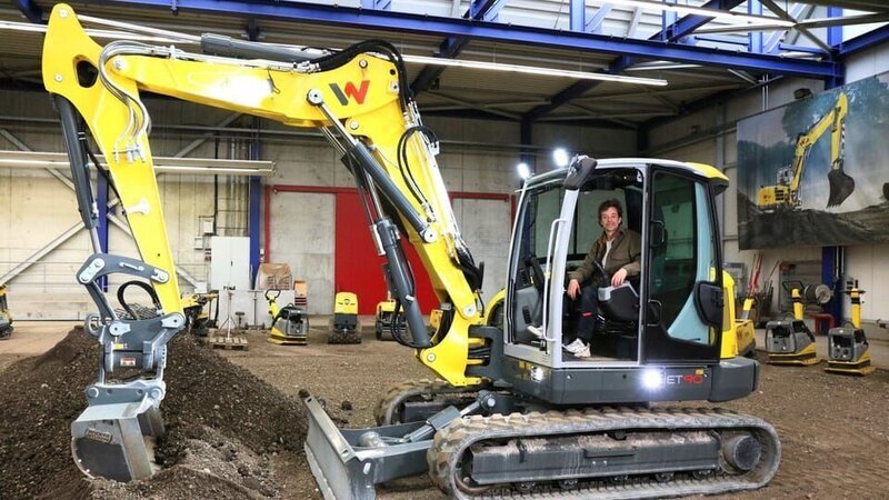 Tobi darf in einer Übungshalle mit einem Bagger ein Loch baggern. – Bild: BR /​ megaherz gmbh /​ Lynn Klockow