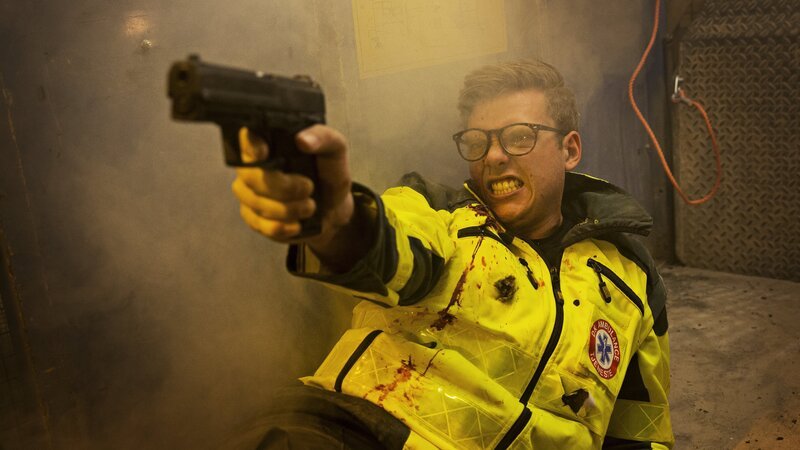 Der als Sanitäter verkleidet Polizist (Emil Sebastian Gohr) erwidert das Feuer der Geiselnehmer. – Bild: ZDF/​Christian Geisnæs