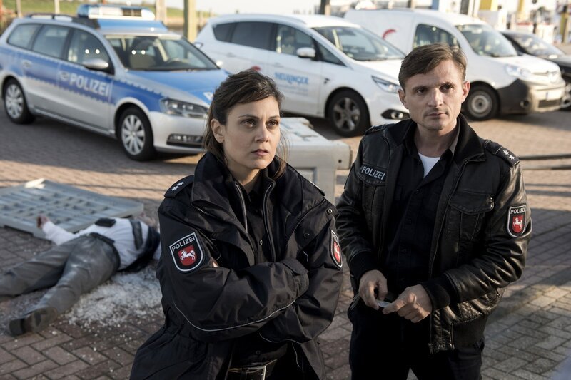 Süher Özlügül (Sophie Dal) und Jens Jensen (Florian Lukas) stoßen bei der Spedition „Heulinger Meeresfrucht“ auf die Leiche des Geschäftsführers Klaus Heulinger. – Bild: PLURIMEDIA (ZDF /​ Martin Valentin Menke)