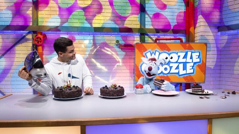 Woozle (re.) möchte einen Schokokuchen nach dem Rezept seiner Tante Woozefine backen – wenn das Rezept bloß auffindbar wäre! Simón (li.) hilft beim Verkosten und Bewerten von Woozles Backkünsten. – Bild: Annette Etges/​SUPER RTL