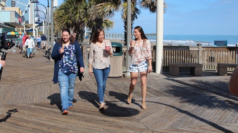 Bargain hunter Brittany (M) and two sisters Erica (R) and Lindsay (R) enjoy their ice cream while walking down Myrtle Beach’s boardwalk, as seen on HGTV’s original series, Beachfront Bargain Hunt. – Bild: Discovery, Inc.
