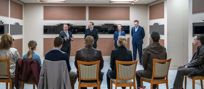 Ministerpräsident Armin Laschet schwört die Ermittler ein: Sie sollen den Serienmörder stoppen, der schon vier Kommissare in Nordrhein-Westfalen tötete. Der Polizeipräsident Ullrich Dettmers stellt die Coaches Martin und Christoph Scholz vor. Sie sollen aus sieben Ermittlern ein effizientes Team formen: Nadine Möller, Nadeshda Krusenstern, Sascha Ziesing, Marcus Rettenbach, Martina Bönisch, Peter Faber, Franz Mitschowski. – Bild: WDR/​Tom Trambow