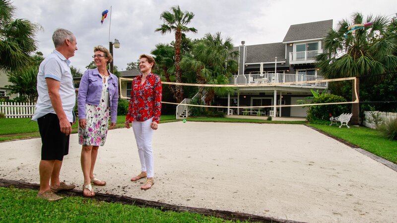 Gulf Breeze homebuyers Richard and Lorraine wrap up their tour of the Soundside House with real estate agent Robin Sherman on the beach volleyball court, as seen on HGTV’s Beach Hunters. – Bild: HGTV /​ ;HBCHU203_277336_1031184.JPG /​ HGTV/​Scripps Networks, LLC. All Rights Reserved