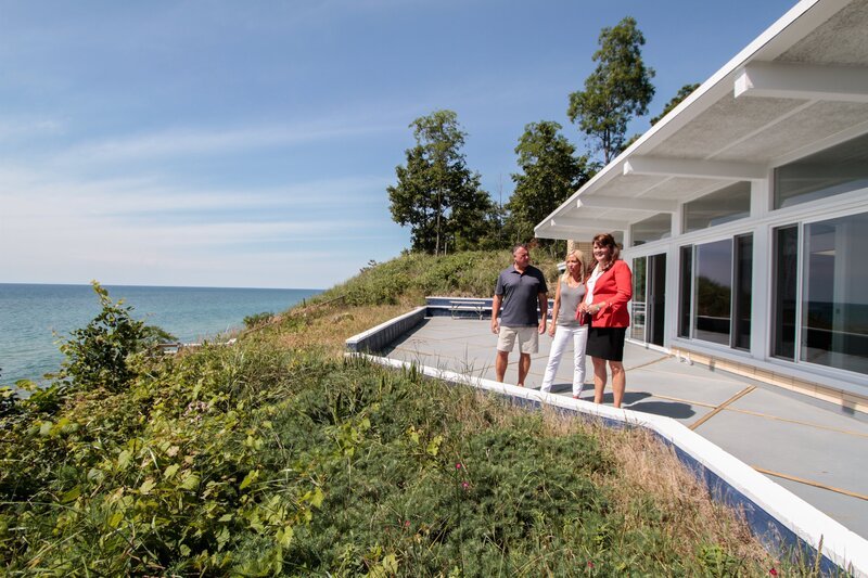 Real estate agent Ronda Busscher shows off the 75-feet of waterfront at the Cali Beach House to homebuyers Darren and Cindy. – Bild: 2017, HGTV /​ Scripps Networks, LLC. All Rights Reserved