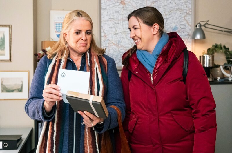 Nachdem Philipp Pralinen in der Amtsstube vergessen hat, überzeugt Sophia (Patricia Freund, rechts) Ulla (Sabrina Dietel, links, KLD), dass er sich in Ulla verknallt hat. – Bild: BR/​Lena Semmelroggen