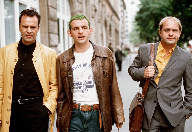 Der Literaturprofessor Hartmut Popp (Uwe Ochsenknecht, re.) verlässt mit seinen Freunden Jürgen Dux (Dominique Horwitz, Mitte) und Robert Merten (Peter Sattmann) entnervt den Campus. – Bild: ARD Degeto