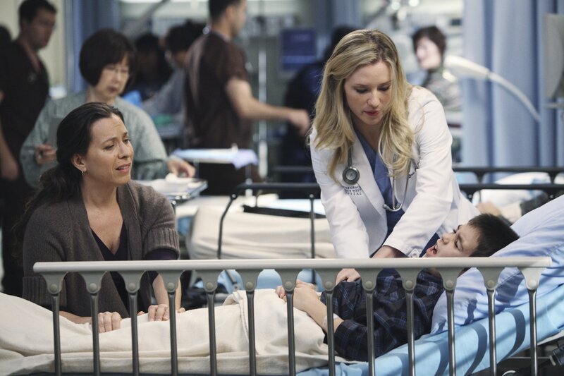 Lexie (Chyler Leigh, M.) kümmert sich um Noah (Aidan Walter, r.), der mit Schmerzen ins Seattle Grace Hospital eingeliefert wurde, während seine Mutter Kelly (Moon Zappa, l.) sich große Sorgen macht … – Bild: American Broadcasting Companies, Inc. /​ Adam Larkey