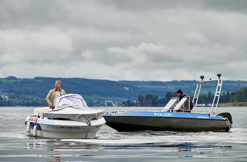 Paul Schott (Tim Wilde, r.) stellt Mikey Radny (Martin Wißner, l.) nach einer Verfolgungsfahrt auf dem Bodensee, weil der versucht hatte sich einem Verhör zu entziehen. – Bild: ARD/​Nicolas Gradicsky