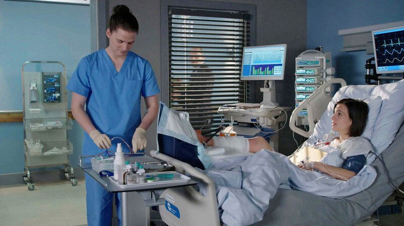 Tom (Tilman Pörzgen, l.) bereitet Sina (Zeynep Bozbay, l.) auf die Untersuchung vor. Sie probieren alles, um ihr Bein zu erhalten. – Bild: ARD/​Jens Ulrich Koch