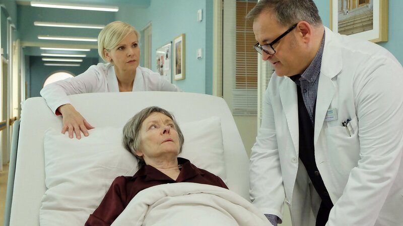 Dr. Kathrin Globisch (Andrea Kathrin Loewig, li.) muss Luise Brenner (Monika Lennartz, liegend) sofort operieren. Hans-Peter Brenners (Michael Trischan, re.) Mutter leidet an Krebs und hat einen akuten Darmverschluss. – Bild: Sebastian Kiss