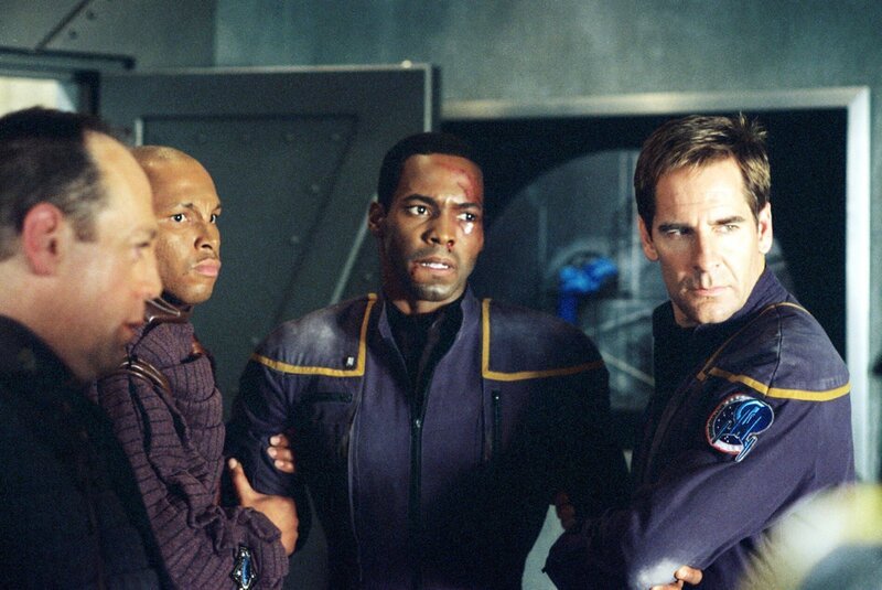 Weil Ensign Mayweather (Anthony Montgomery, 2.v.r.) die harte Hand des Aufsehers Major Klev (David Kagen, l.) zu spüren bekommen, wächst in Captain Archer (Scott Bakula, r.) der Widerstand … – Bild: TM CBS Studios Inc /​ Paramount Pictures /​ SYFY