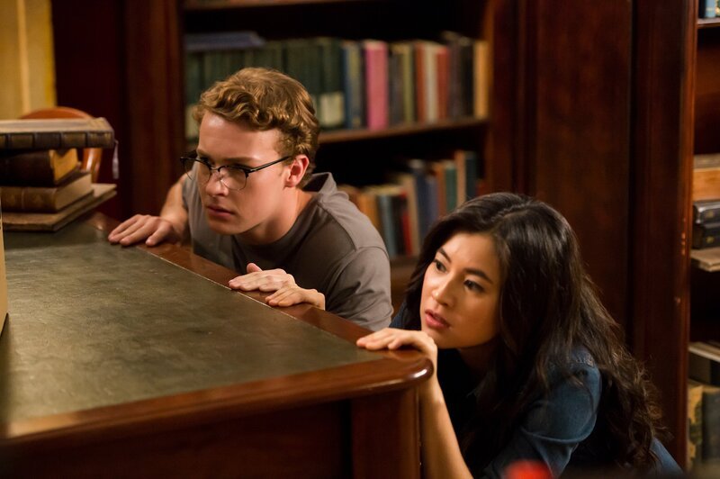 Kyra (Kimie Tukakoshi, rechts) hat Peter (Jamie Carter, links) heimlich mit in die Bibliothek genommen. Als sie Geräusche hören, verstecken sie sich. Sie wollen nicht entdeckt werden. – Bild: ZDF/​Jonathan M. Shiff Productions/​Screen Queensland