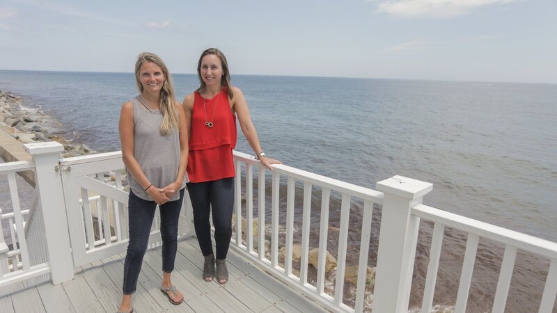 As seen on HGTV’s Beach Hunters, homebuyer Melanie and friend Paige pose for a photo during their tour of the Rocky Point House along Massachusetts’ South Shore. – Bild: WSP 6D DS1 /​ HGTV /​ HBCHU204_278056_1035111.JPG /​ HGTV/​Scripps Networks, LLC. All Rights Reserved