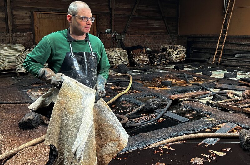Thomas Martin gerbt Leder mit Baumrinde und Wasser. Mindestens 2 Jahre ruhen die Tierhäute in der Gerbbrühe bevor sie zu Sohlenleder weiterverarbeitet werden. – Bild: SWR/​Thomas Schäfer