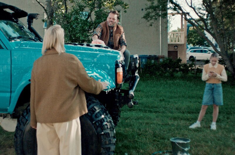 Als Magnus (Björn Thors, Mi.) seinen Geländewagen mit chemischen Mitteln im Garten wäscht, bekommt er von Ditte (Trine Dyrholm, li.) eine Standpauke – direkt vor seiner Tochter Maja (Kolbrún Helga Friðriksdóttir, re.). – Bild: Slot Machine