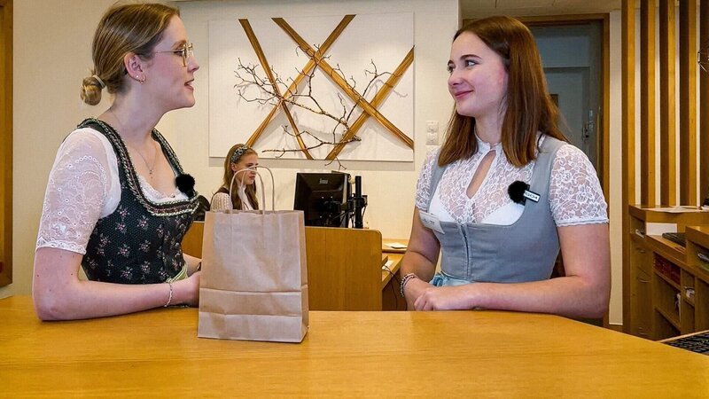 Lena bei Helene (re.) an der Rezeption, sie macht hier ihre Lehre. – Bild: ORF
