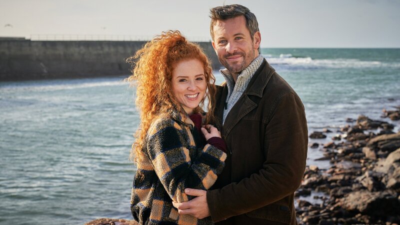 Rosamunde Pilcher Der Stoff, aus dem die Träume sind Glücklich vor wilder Kulisse: Sarah Hannemann als Lilly Heartfield, Jan Hartmann als Aidan Wilson – Bild: SRF/​ZDF/​Jon Ailes