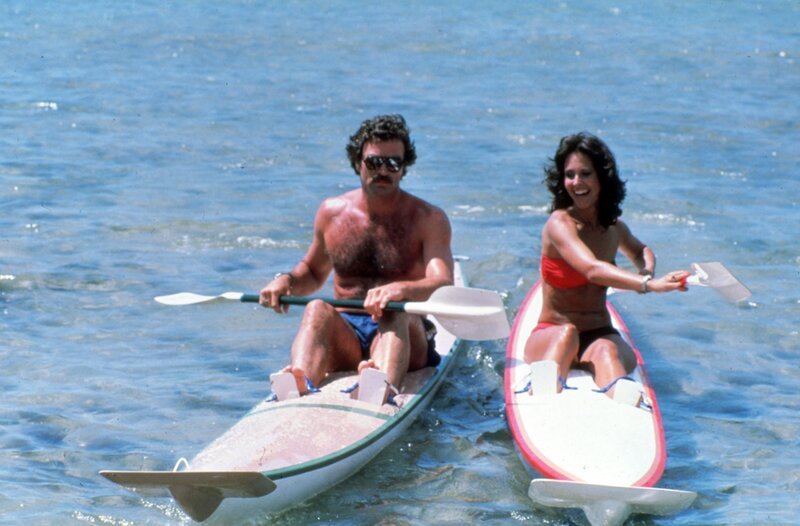 Jemand versucht, die Veröffentlichung von Robin Masters’ neuem Buch zu verhindern. Masters engagiert Joy ‚Digger‘ Doyle (Erin Gray, r.), um die Aufzeichnungen zu sichern. Magnum (Tom Selleck, l.) ist eifersüchtig … – Bild: Universal City Studios LLLP. All Rights Reserved.