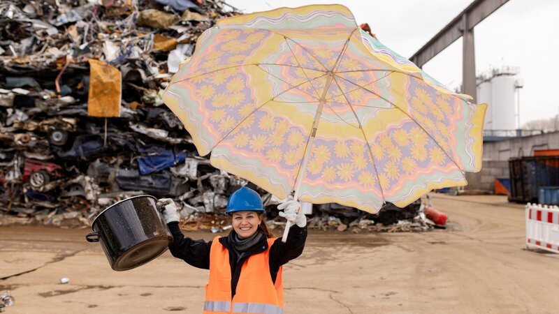 Checkerin Marina ist auf einem Schrottplatz unterwegs und schaut sich an, wie Schrott weiterverarbeitet wird. – Bild: BR/​megaherz gmbh/​Hans-Florian Hopfner