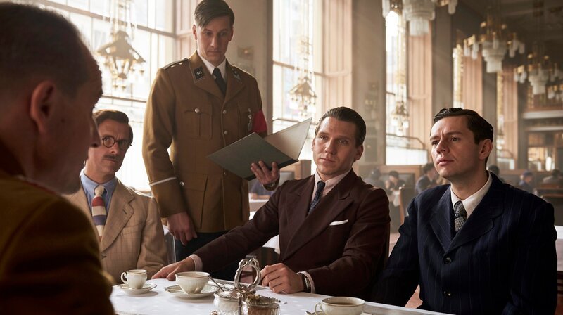 Josef Waitzer (Christoph Maria Herbst, 2. v. li.), und die Dassler-Brüder Rudi (Hanno Koffler, 2. v. re.) und Adi  (Christian Friedel, re.) mit einem Parteifunktionär im Rahmen der Vorbereitung auf die Olympischen Spiele 1936 – Bild: ARD Degeto/​Wiedemann & Berg/​Martin Spelda