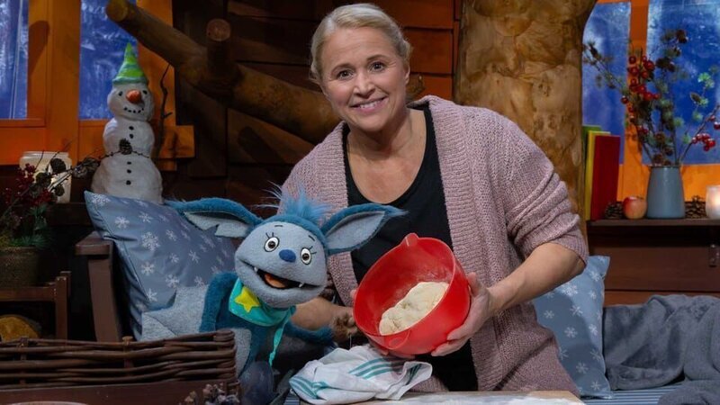 Singa erklärt Fidi, dass sie für den Dreikönigstag einen Hefekranz backt, der zwei ganz besondere Überraschungen bereit hält. – Bild: KiKA