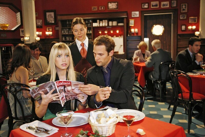 Enttäuscht blättert Kim gemeinsam mit Paolo in der Glamour-Presse. Niemand hat von ihren repräsentativen Bemühungen Notiz genommen. – Bild: SAT.1 /​ Monika Schürle