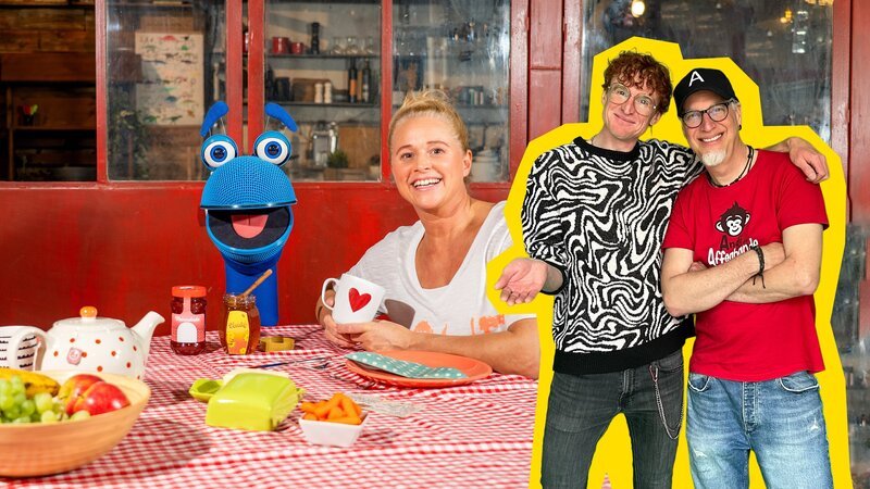 Singa und SingDing unterhalten sich beim Frühstück über verschiedene Sprachen und Dialekte. Manchmal ist es gar nicht so leicht sich gegenseitig zu verstehen. Tommi und Andi wissen Rat. – Bild: ZDF/​Tim Bornemann