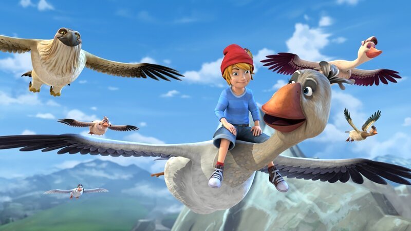 Nachdem Nils Akka gerettet hat, darf er auf ihrem Rücken fliegen und die Schar anführen. – Bild: BR/​Studio 100 Animation/​Studio 100 NV