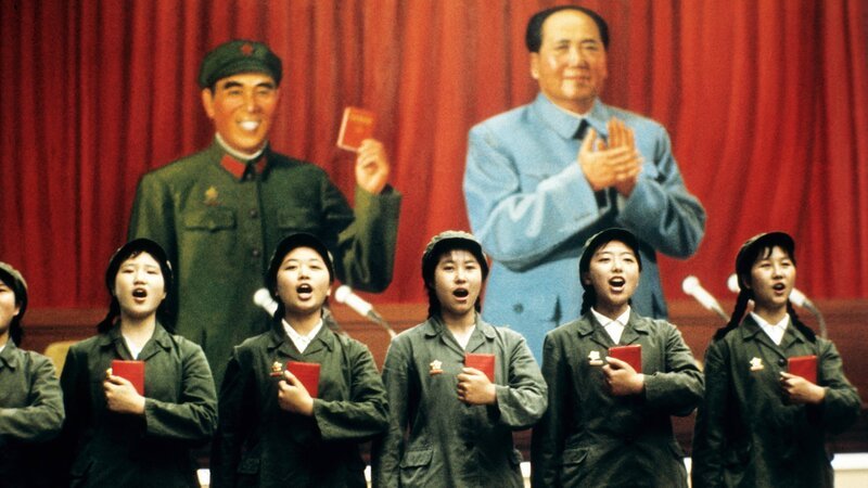 SRF school Mao – Chinas roter Kaiser: Kulturrevolution Singende Student:innen vor einem Poster mit Mao und Lin Biao – Bild: SRF/​IMAGO/​Sepp Spiegl