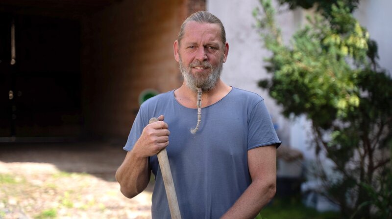 Auf dem Land noch einmal neu anfangen, die Enge, den Lärm und den Dreck der Stadt hinter sich lassen. Davon träumt jeder zweite Mensch in deutschen Ballungsräumen. – Betonbauer Marcus (47) leidet in seinem günstig ergatterten Hof im Fläming unter Einsamkeit. Das Alleinsein führt bei ihm fast zu einer Depression. Ein Bandscheibenvorfall und ruinierte Knie sind eine Folge der harten Arbeit am Haus. Ging es ihm in Berlin nicht doch irgendwie besser? – Bild: rbb/​Matthias Neumann
