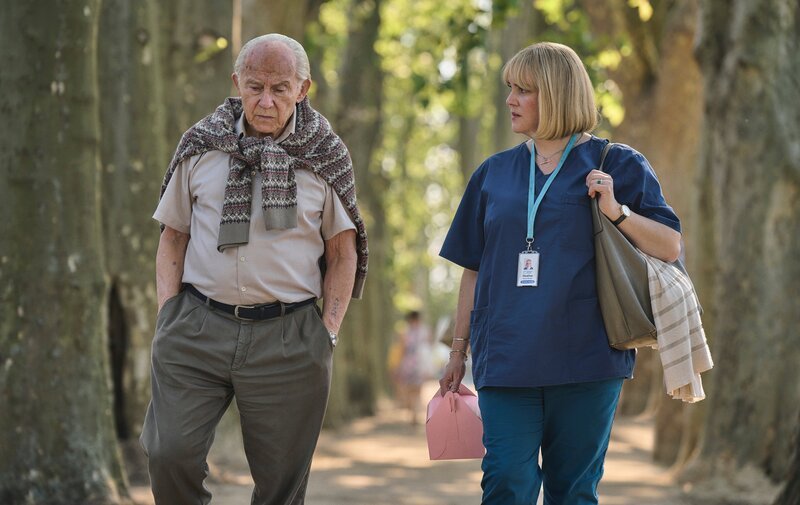 Harvey Keitel as Lali Sokolov and Melanie Lynskey as Heather Morris walking through the streets of Melbourne. – Bild: Martin Mlaka /​ Sky UK