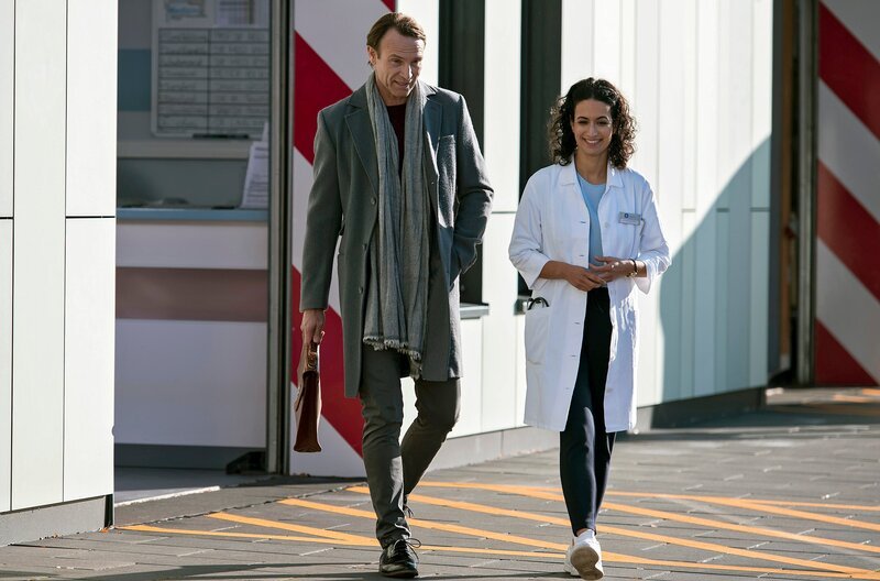 Dr. Stein (Bernhard Bettermann, l.) kommt aus der Sachsenklinik nach Erfurt, um gemeinsam mit Leyla (Sanam Afrashteh, r.)  das Traumazentrum voranzubringen. – Bild: ARD/​Jens Ulrich Koch